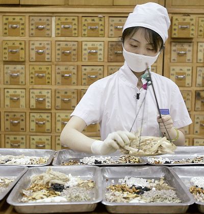 A Chinese pharmacy worker prepares herbs at the Beijing Traditional Chinese Medicine Hospital in Dongcheng district on July 23 last year. 