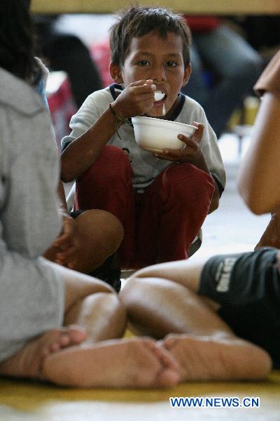 Children wait in line for food provided by NGO at an evacuation center in Manila, Philippines, Oct. 19, 2010. 