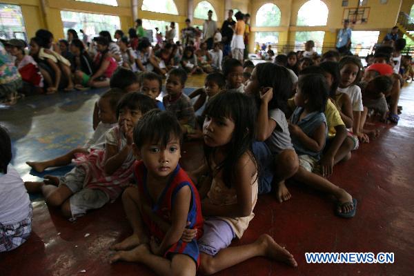 Children wait in line for food provided by NGO at an evacuation center in Manila, Philippines, Oct. 19, 2010. 