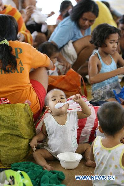 A boy eats a bowl of porridge provided by NGO at an evacuation center in Manila, Philippines, Oct. 19, 2010. 