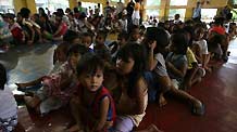 Children wait in line for food provided by NGO at an evacuation center in Manila, Philippines, Oct. 19, 2010.