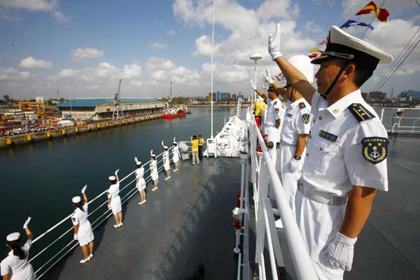 Chinese officers aboard the Chinese navy hospital ship Peace Ark wave greetings to the welcoming crowd at the port of Dar es Salaam, Tanzania, Oct 19, 2010. 