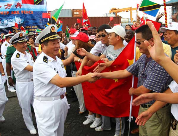 Bao Yuping (foreground), commander of the hospital ship Peace Ark of the Navy of the Chinese People&apos;s Liberation Army, receives a warm welcome from overseas Chinese in Dar es Salaam, Oct 19, 2010. 