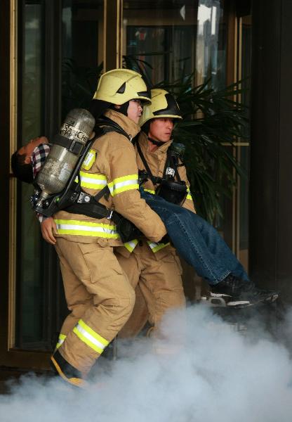 An 'injured person' is carried out from the Millennium Seoul Hilton Hotel while taking part in the anti-terror exercises simulating a chemical weapons attack in Seoul, South Korea, on Oct. 20, 2010. 