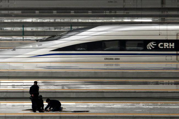 Railway workers inspect Shanghai Hongqiao Railway Station as a CRH380A train idles in the background on Oct. 20th, 2010. 