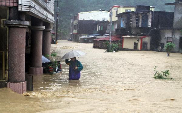 A resident makes his way forward in a flooded street in Ilan County, southeast China's Taiwan, Oct. 21, 2010.
