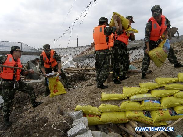 Soldiers reinforce the river bank as Typhoon Megi, possibly the strongest to hit China this year, draws near, in Longhai City, southeast China's Fujian Province, Oct. 22, 2010. 