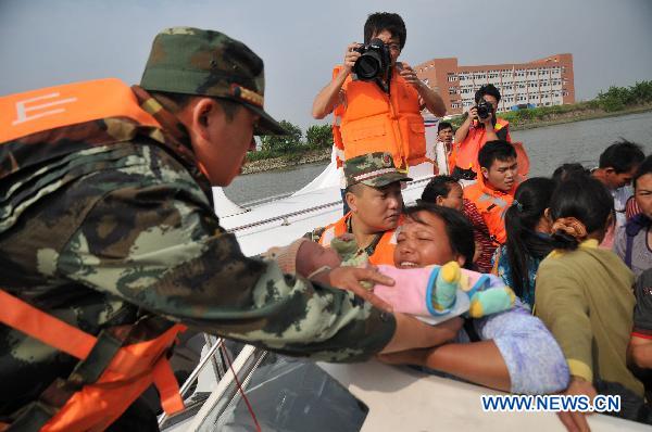 Soldiers evacuate the residents as Typhoon Megi, possibly the strongest to hit China this year, draws near, in Zhongshan, south China's Guangdong Province, Oct. 21, 2010. The typhoon is forecast to land somewhere between Huilai in south China's Guangdong Province and Xiamen of Fujian Province on Saturday. 
