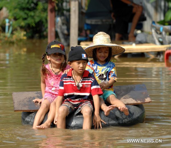 Children row a tyre in water in Ayutthaya, about 80 kilometers north to Bangkok, on Oct. 22. 2010. 