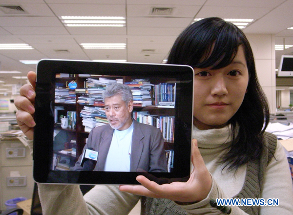 A staff member with Xinhua News Agency shows an iPad broadcasting Chinese news reporting of the Xinhua television service, CNC, in Beijing, capital of China, Oct. 24, 2010. 