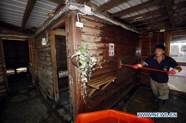 A resident cleans a house in Su'ao, southeast China's Taiwan, on Oct. 24, 2010.