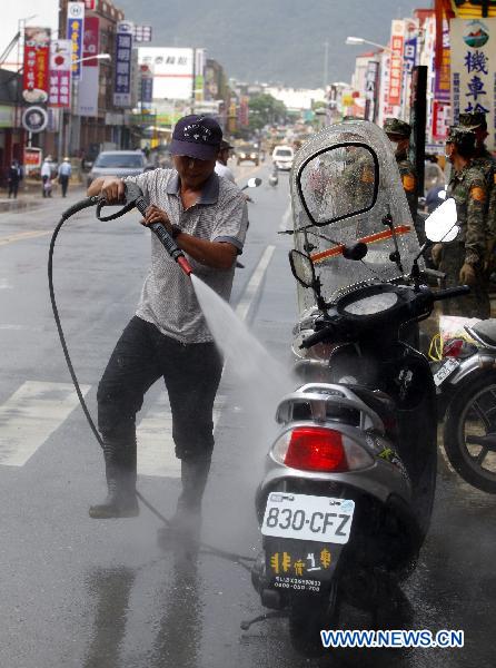 A man cleans a motorbike in Su'ao, southeast China's Taiwan, on Oct. 24, 2010. L