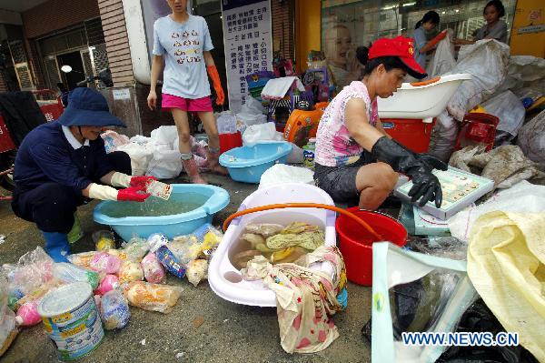 People clean their belongings in Su'ao, southeast China's Taiwan, on Oct. 24, 2010. 