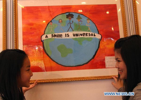 Gilrs visit a picture exhibition celebrating the 65th UN Day in Beijing, capital of China, Oct. 25, 2010. 