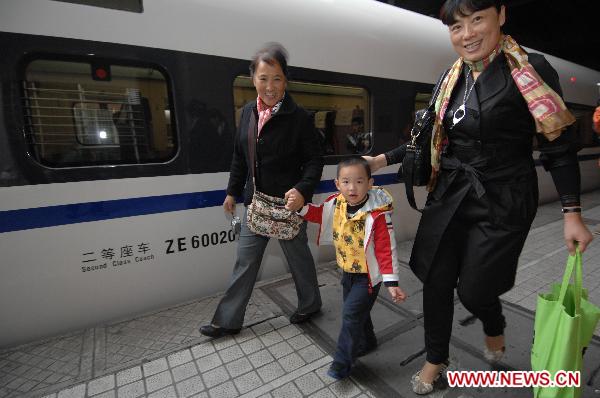 A boy walks with his family before boarding onto the first train of the newly operated high speed railway from Hangzhou to Shanghai in Hangzhou, east China's Zhejiang Province, Oct. 26, 2010. 