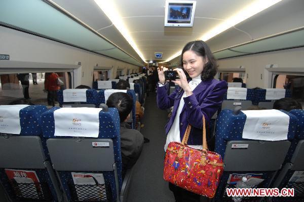 A woman takes photos in the first train of the newly operated high speed railway from Hangzhou to Shanghai in Hangzhou, east China's Zhejiang Province, Oct. 26, 2010. The 202 km Shanghai-Hangzhou high-speed railway, with a design speed of 350km per hour, began its operation Tuesday morning. 