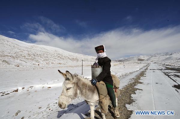 A herdsman of Tajik ethnic group rides on a road on the Pamirs in northwest China's Xinjiang Uygur Autonomous Region, Oct. 23, 2010. 