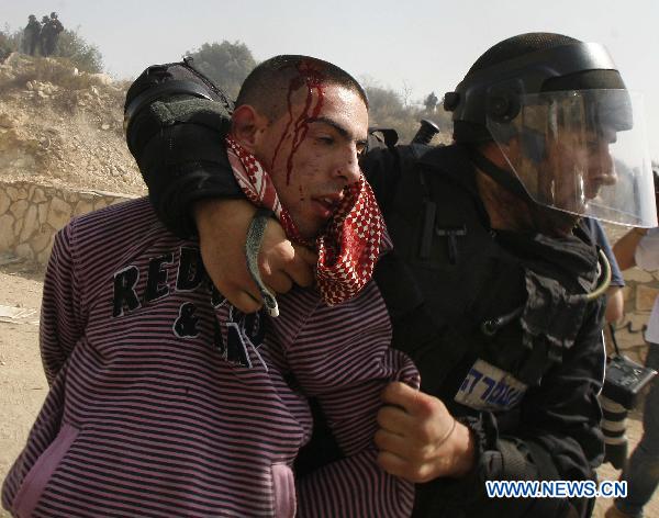 An Israeli riot police officer detains a protester during clashes in Umm el-Fahm Oct. 27, 2010. 