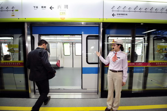 A train staffer guides passengers onto China's first intercity underground subway - the Guangzhou-Foshan Line - on Oct 28,2010. 
