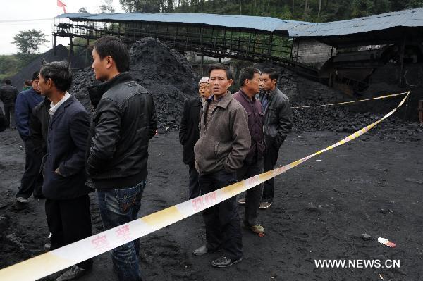 People stand outside the flooded Dapo coal mine in Machang Town of Puding County under Anshun City, southwest China&apos;s Guizhou Province, Oct. 28, 2010.