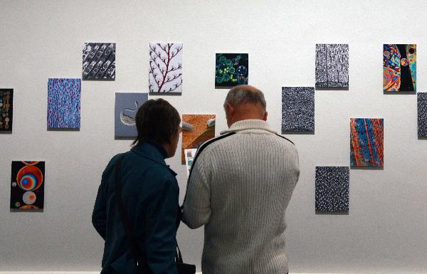 People visit a micro photo exhibition in Berlin, Germany, Oct. 28, 2010. This exhibition opened on Oct. 1, 2010 and will last till Jan. 9, 2011.