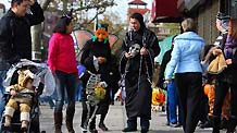 Children in Halloween costume walk with their parents on a street in New York, the United States, Oct. 31, 2010.