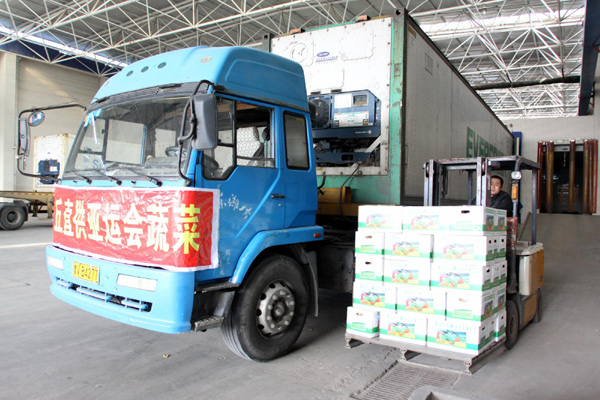 A worker in Anqiu, east China's Shandong Province, loads boxes of vegetables onto a truck to be transported to Guangzhou, Nov 1, 2010.