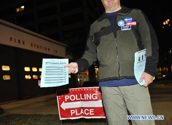 A man distributes leaflets at a polling station in Arlington, Virginia, the United States, Nov. 2, 2010, the US Midterm Election Day.