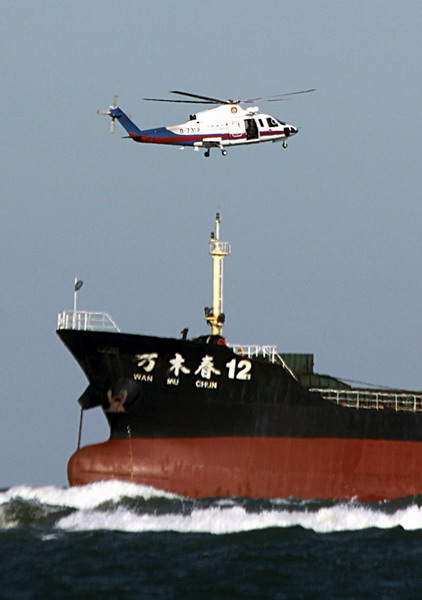 The stranded freighter is reached by a rescue helicopter about 300 meters from the mouth of Shuangdao Bay in Weihai, East China&apos;s Shandong province, Nov 2, 2010. [Xinhua]
