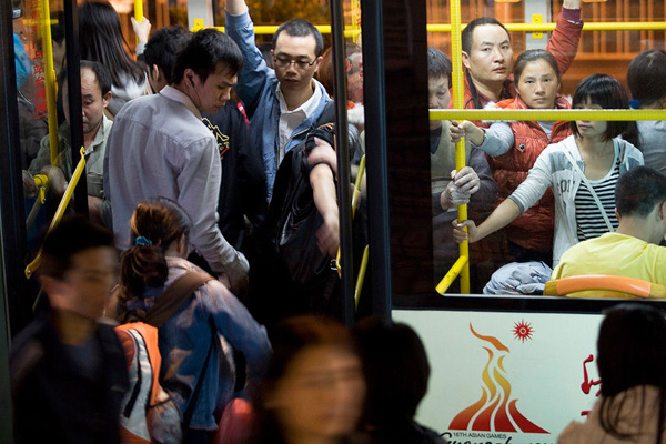 Passengers in Guangzhou, Guangdong Province, get on the bus from the rear door instead of swiping their cards at the front door on Monday. During the 30 work days of the Asian Games and Paralympic Games, passengers are able to ride public transportation for free.