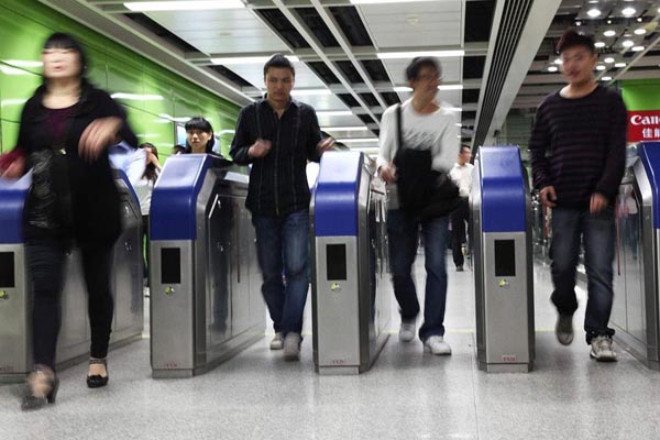 Passengers exit Gangding subway station on Line 3 in Guangzhou on Monday.