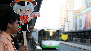 A public transportation worker guides passengers onto buses at a BRT platform in Guangzhou on Monday. During the 30 work days of the Asian Games and Paralympic Games, passengers are able to ride public transportation for free.