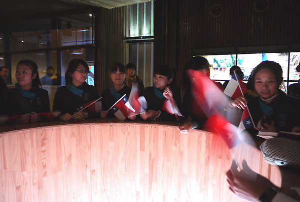 Staff members of Chile Pavilion wave Chilean flags at pavilion&apos;s closing ceremony on Sunday.