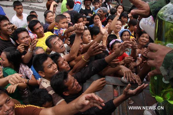 Flood refugees reach out to get the relief materials in Hat Yai City of south Thailand's Songkhla Province Nov. 4, 2010.