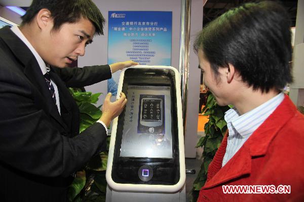 A participant promotes financial products at the Sixth Beijing International Finance Expo in Beijing, capital of China, Nov. 4, 2010.
