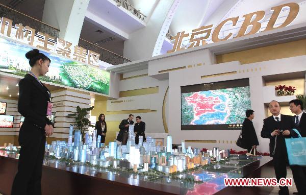 Visitors look at models of Beijing Central Business District at the Sixth Beijing International Finance Expo in Beijing, capital of China, Nov. 4, 2010