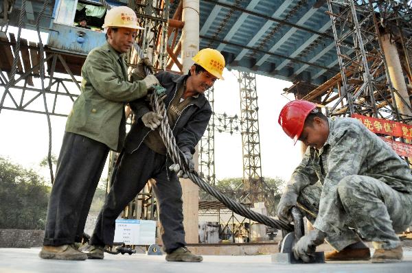 Workers make efforts at a construction site of the railway between Nanning and Qinzhou in Nanning, capital of south China's Guangxi Zhuang Autonomous Region, Nov. 3, 2010. 