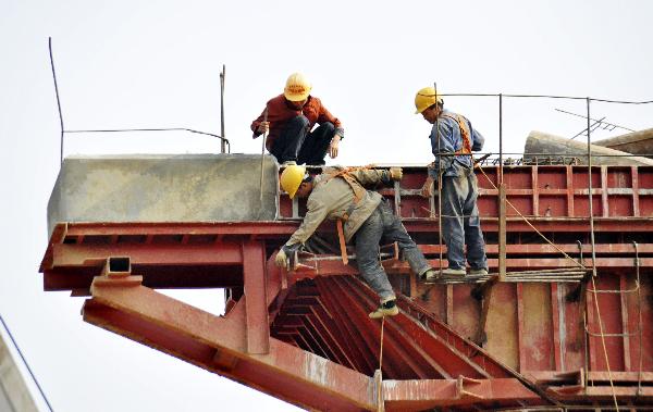 Workers make efforts at a construction site of the railway between Nanning and Qinzhou in Nanning, capital of south China's Guangxi Zhuang Autonomous Region, Nov. 3, 2010.