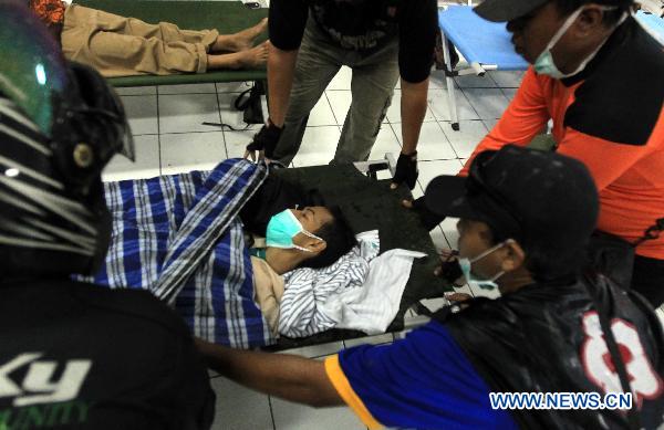 An injured person is carried to the infirmary in the Maguwoharjo Stadium, a temporary refuge center set up by local government after Volcano Merapi&apos;s latest re-eruption, in Yogyagarta, Central Java of Indonesia, Nov. 5, 2010. 