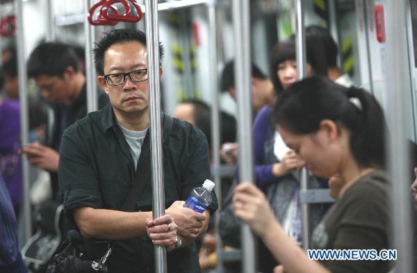 The photo taken on Nov. 8, 2010 shows commuters aboard a tube train in Guangzhou, south China's Guangdong Province. 