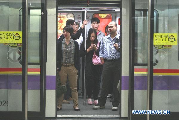 The photo taken on Nov. 8, 2010 shows commuters aboard a tube train in Guangzhou, south China's Guangdong Province.