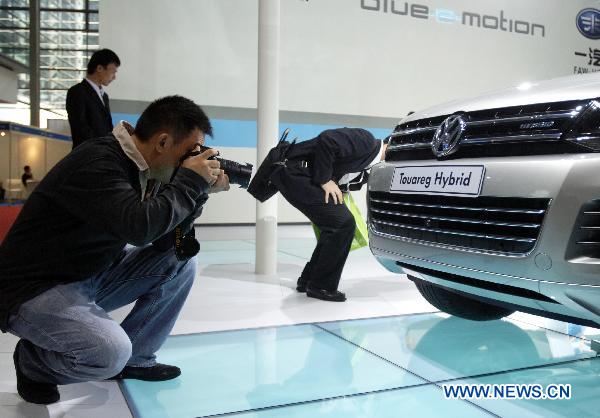 A visitor takes photo of a Volkswagen hybrid vehicle during the 25th World Battery, Hybrid and Fuel Cell Electric Vehicle Symposium and Exposition in Shenzhen, south China's Guangdong Province, Nov. 7, 2010. 