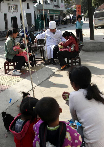 Dr. Xu Yufu attends to his patients on the street at Quangang village of Tongshan County in Xianning City, central China&apos;s Hubei Province, November 9, 2010.