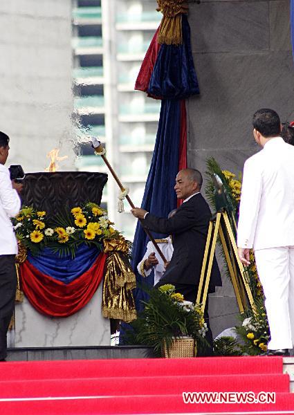 Cambodian King Norodom Sihamoni lights the cauldron to symbolize the country's independence from colonial rule during a ceremony to celebrate the 57th anniversary of independence of Cambodia in Phnom Penh, on Nov. 9, 2010. 