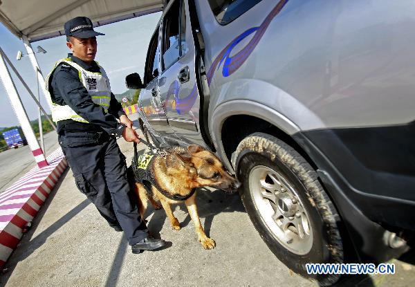 A sniffer dog checks a vehicle at an highway entrance to Guangzhou, capital of south China&apos;s Guangdong Province, Nov. 10, 2010. 