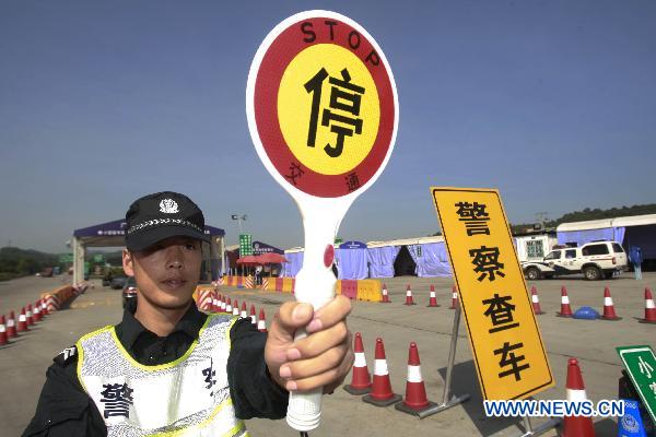 A policeman conducts security check at a highway entrance to Guangzhou, capital of south China&apos;s Guangdong Province, Nov. 10, 2010. 