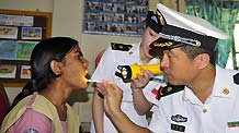 Liu Shisen (R) conducts oral examination for a girl at a handicapped children's center in Chittagong, Bangladesh, Nov. 10, 2010.