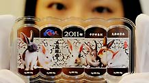 A jewelry staffer displays silver bullions embedded with colored rabbits at a jewelry store in Suzhou, East China's Jiangsu province on Nov 11,2010. To maximize profits, many jewelry stores have begun to sell new designs for 2011, the Year of the Rabbit in the Chinese lunar calendar.