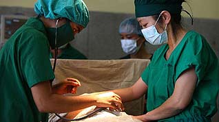 Medical personnel from both Bangladesh and China take part in a caesarean operation on the Chinese Navy hospital ship 'Peace Ark' in Chittagong, Bangladesh, Nov. 12, 2010.