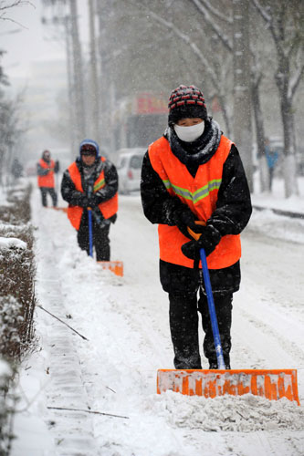 Sanitation workers shovel snow on Saturday from the streets of Harbin, capital of Heilongjiang province. The bad weather began late on Nov. 11, 2010 when snow storms swept Heilongjiang, Jilin and Liaoning provinces and the Inner Mongolia autonomous region, leaving up to 50 centimeters of snow on the ground in places. [Xinhua]